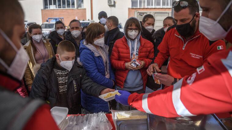 ROME, ITALY - MARCH 22: Ukrainian refugees evacuated from Lviv receive hot meals brought by Italian Red Cross volunteers, on March 22, 2022 in Rome, Italy. About 80 frail people including children, elderly and disabled were evacuated from Lutsk, Kharhiv and Kiev by the Italian Red Cross in collaboration with the Civil Protection Department. (Photo by Antonio Masiello/Getty Images)