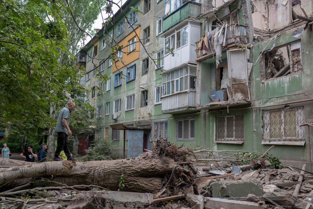 Residentes caminan entre los escombros que dejan ataques en Donetsk