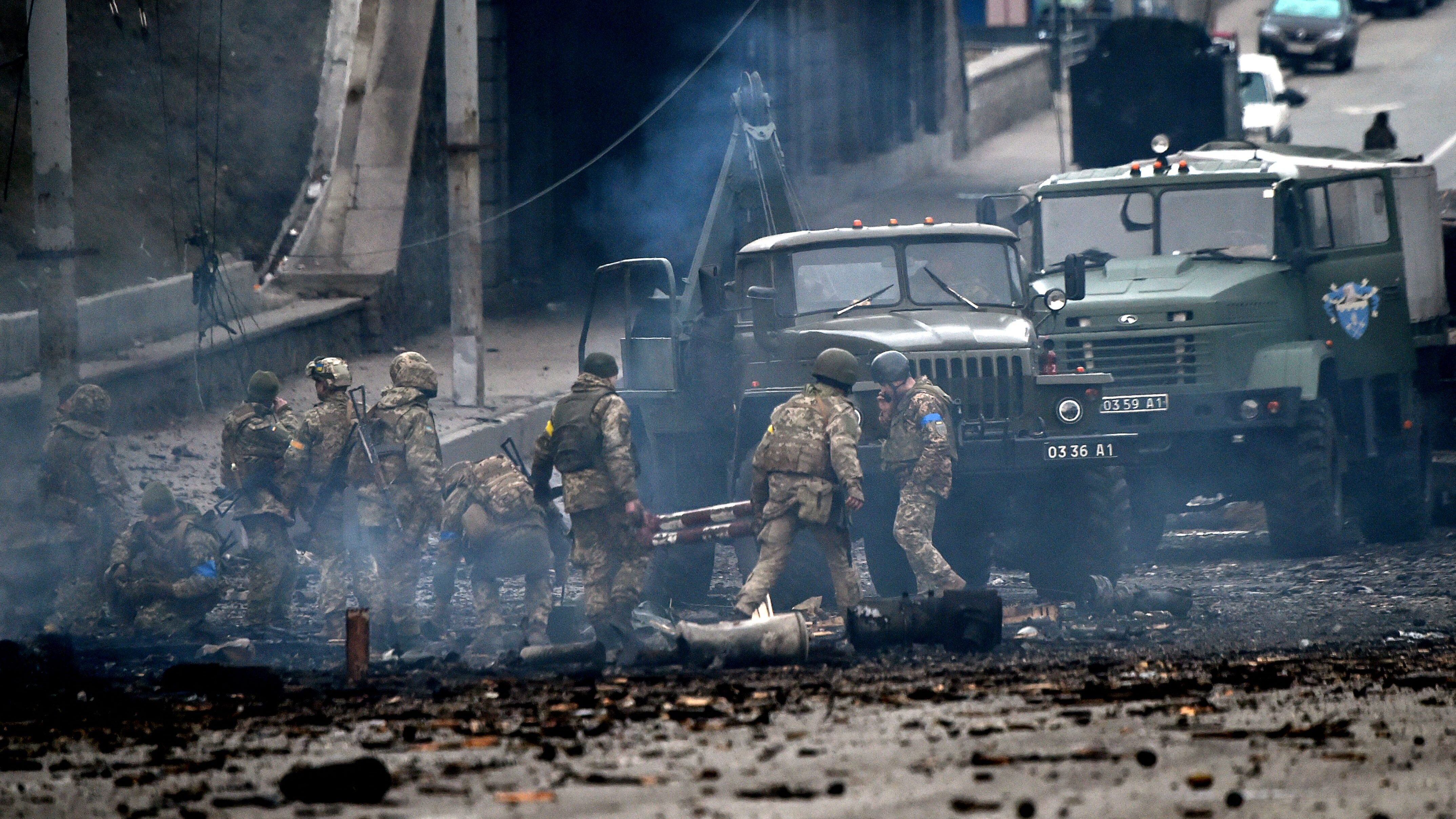 Ukrainian service members collect unexploded shells after a fighting with Russian raiding group in the Ukrainian capital of Kyiv in the morning of February 26, 2022, according to Ukrainian service personnel at the scene. - Ukrainian soldiers repulsed a Russian attack in the capital, the military said on February 26 after a defiant President Volodymyr Zelensky vowed his pro-Western country would not be bowed by Moscow. It started the third day since Russian leader Vladimir Putin unleashed a full-scale invasion that has killed dozens of people, forced more than 50,000 to flee Ukraine in just 48 hours and sparked fears of a wider conflict in Europe. (Photo by Sergei SUPINSKY / AFP) (Photo by SERGEI SUPINSKY/AFP via Getty Images)