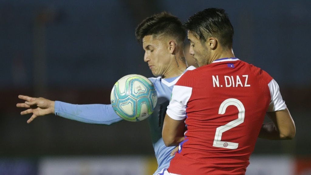 Uruguay's Brian Rodriguez (L) and Chile's Nicolas Diaz vie for the ball during their 2022 FIFA World Cup South American qualifier football match at the Centenario Stadium in Montevideo on October 8, 2020, amid the COVID-19 novel coronavirus pandemic. (Photo by Matilde Campodonico / POOL / AFP) (Photo by MATILDE CAMPODONICO/POOL/AFP via Getty Images)