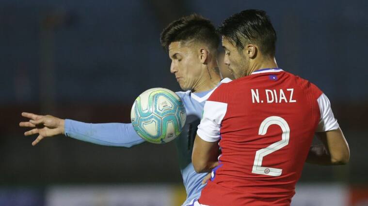 Uruguay's Brian Rodriguez (L) and Chile's Nicolas Diaz vie for the ball during their 2022 FIFA World Cup South American qualifier football match at the Centenario Stadium in Montevideo on October 8, 2020, amid the COVID-19 novel coronavirus pandemic. (Photo by Matilde Campodonico / POOL / AFP) (Photo by MATILDE CAMPODONICO/POOL/AFP via Getty Images)