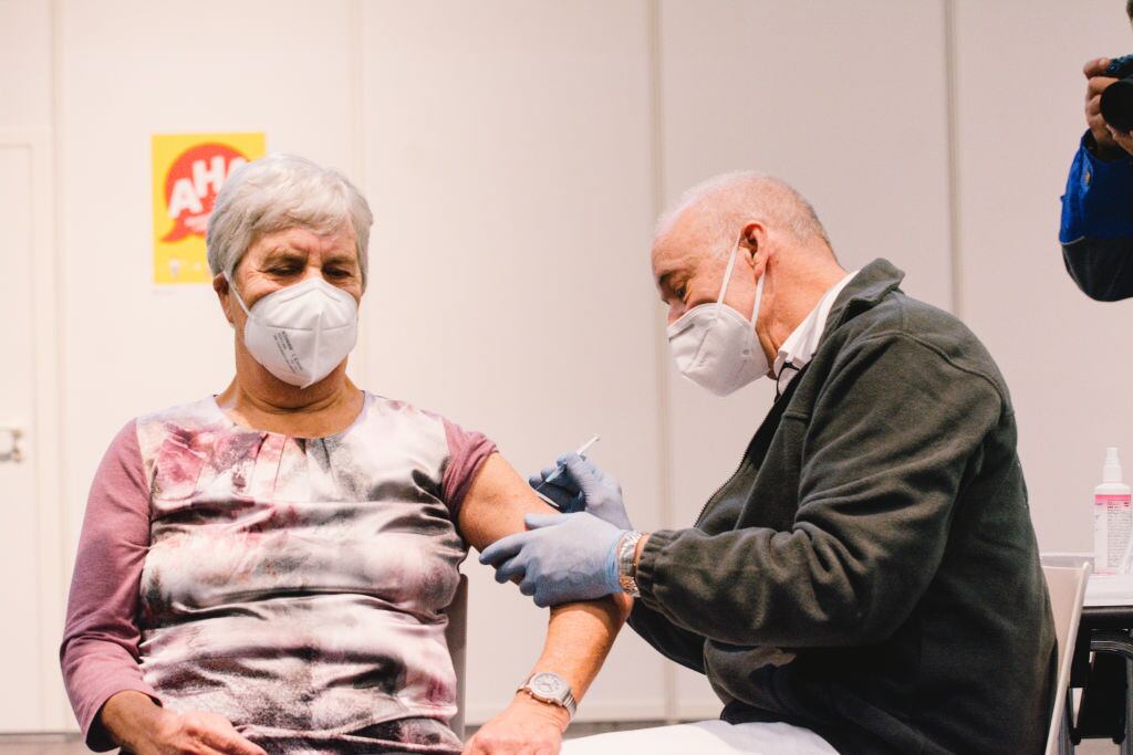 Trabajador de la salud vacuna a una adulta mayor en Colonia