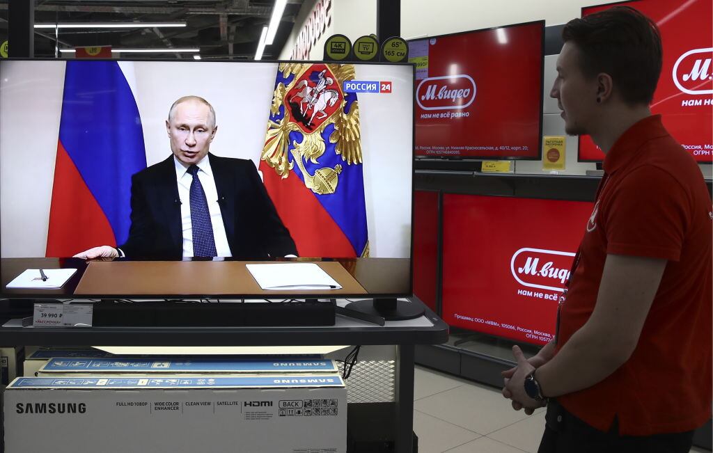 Unos ciudadanos rusos escuchan el anuncio del gobernante ruso Vladimir Putin