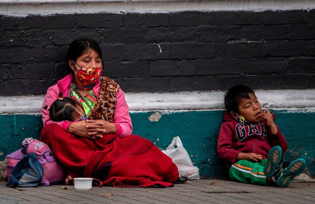 Una mujer con sus dos hijos pide dinero en las calles de Bogotá