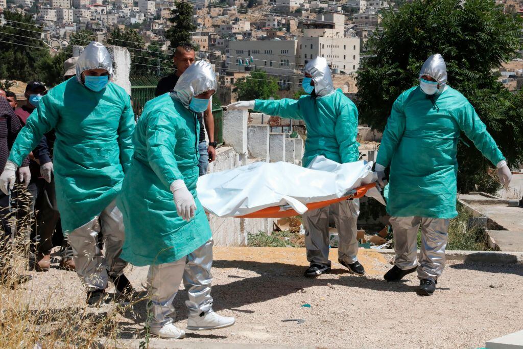 Trabajadores trasladan a víctima del Covid-19 en Palestina