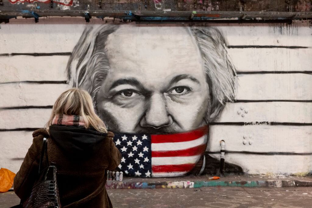 Una mujer observa un graffiti sobre Julian Assange y la censura de Estados Unidos, en un mural ubicado en la ciudad de Londres en Inglaterra.