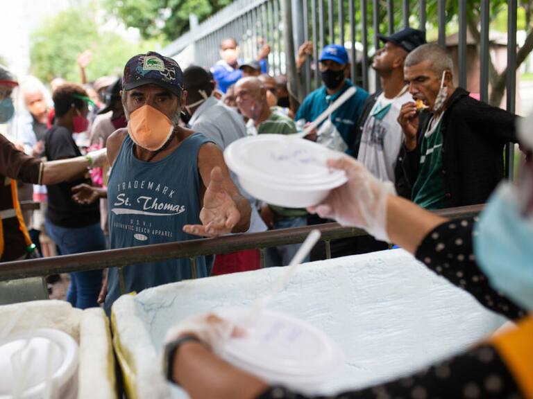 Voluntarios entregan platos con comida en Río de Janeiro