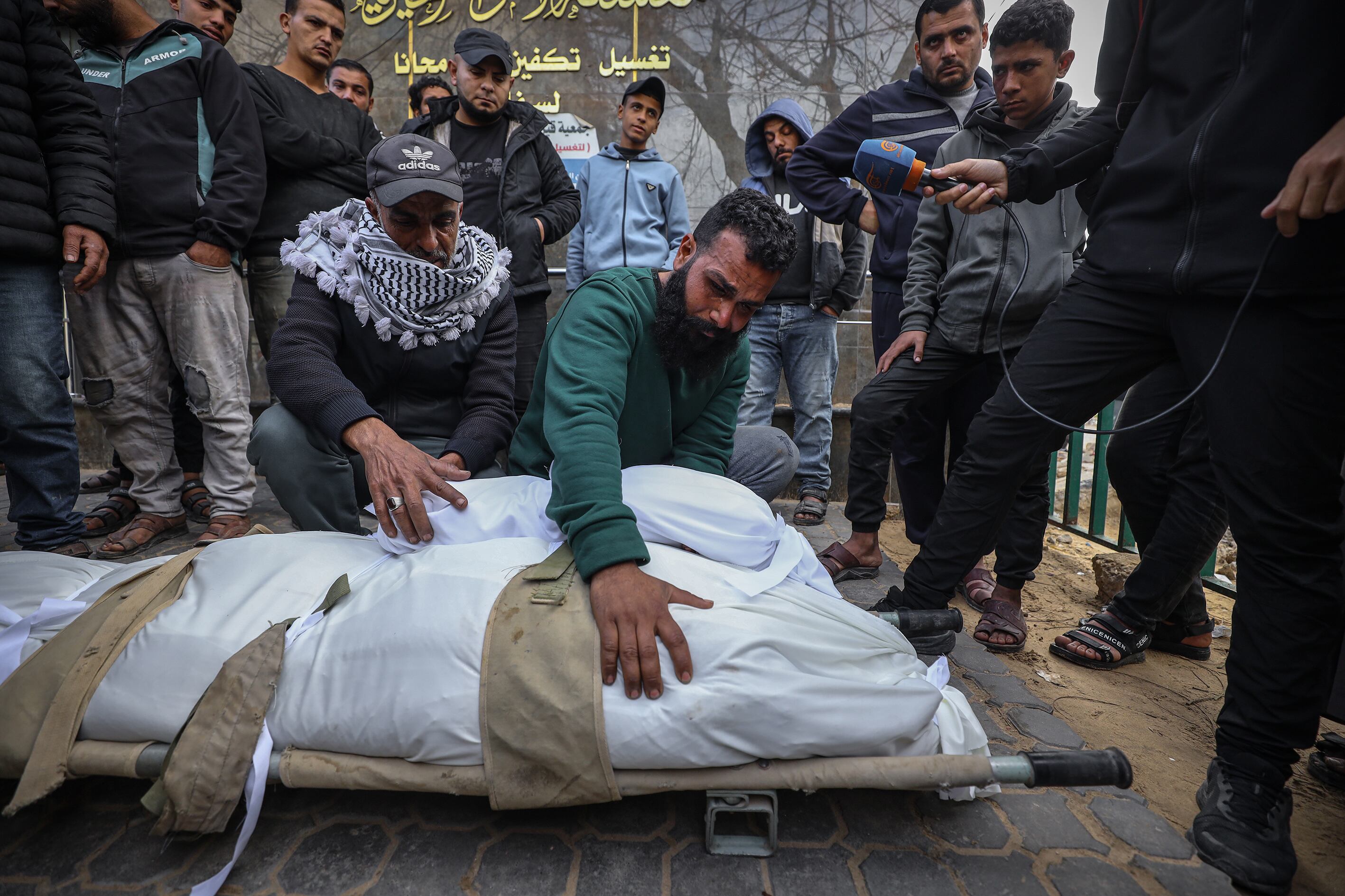 Palestinos despiden a las víctimas mientras los cuerpos de siete personas, entre ellas niños, que perdieron la vida en un ataque israelí pese al alto el fuego, son trasladados al Hospital Al-Shifa para los procedimientos funerarios, en Ciudad de Gaza. (Foto de Khames Alrefi/Anadolu vía Getty Images)