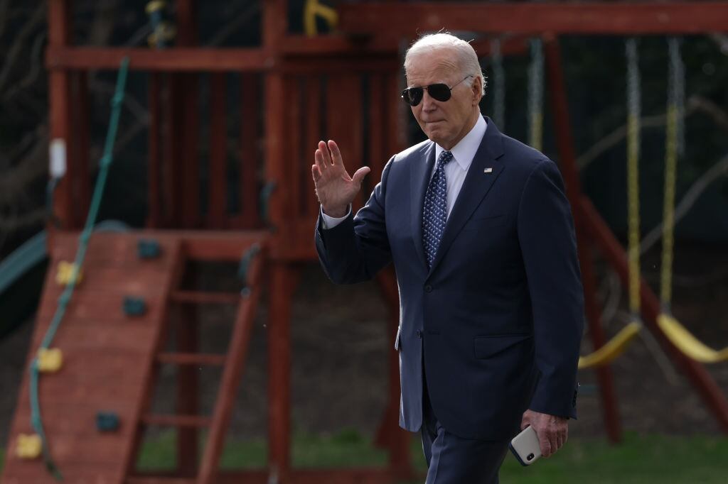 El presidente de Estados Unidos, Joe Biden, saluda a la prensa en momentos que camina por el patio de la Casa Blanca en la ciudad de Washington.
