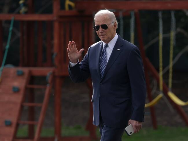 El presidente de Estados Unidos, Joe Biden, saluda a la prensa en momentos que camina por el patio de la Casa Blanca en la ciudad de Washington.