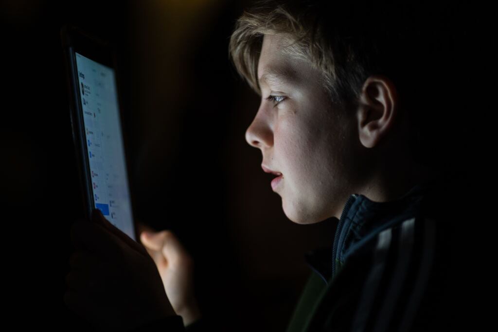 Niño de 12 años utiliza una aplicación en su smartphone en Europa