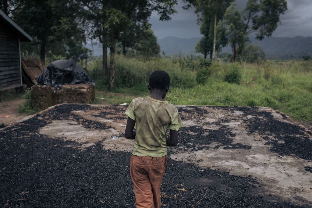 Un niño camina ante escuela incinerada en RD del Congo