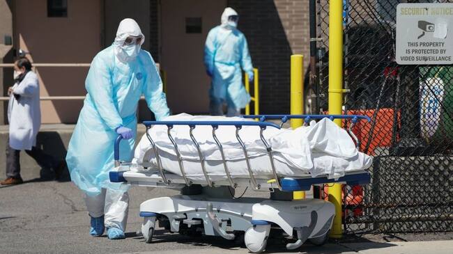 Bodies are moved to a refrigeration truck serving as a temporary morgue at Wyckoff Hospital in the Borough of Brooklyn on April 6, 2020 in New York. - New York Governor Andrew Cuomo on Monday extended a shutdown in the epicenter of America's deadly coronavirus pandemic until near the end of the month. Cuomo said the COVID-19 death rate in New York was "effectively flat" for the past two days but announced that schools and non-essential businesses must stay shut until April 29. (Photo by Bryan R. Smith / AFP) (Photo by BRYAN R. SMITH/AFP via Getty Images)