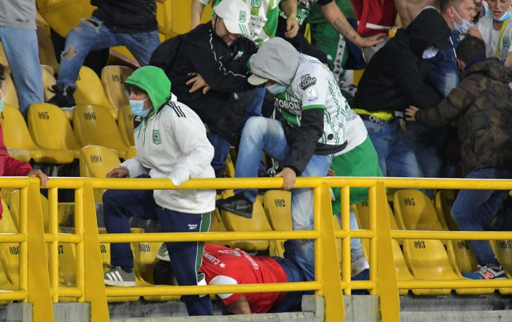 Fanáticos de Atlético Nacional patean en el suelo a un hincha del rival