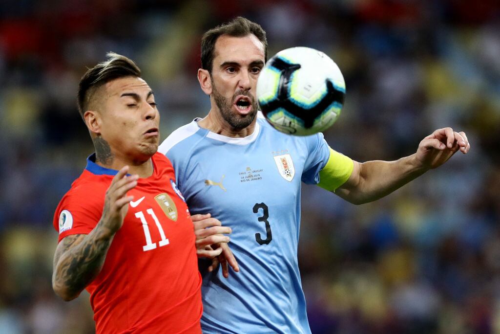 Eduardo Vargas y Diego Godín en un partido Chile-Uruguay