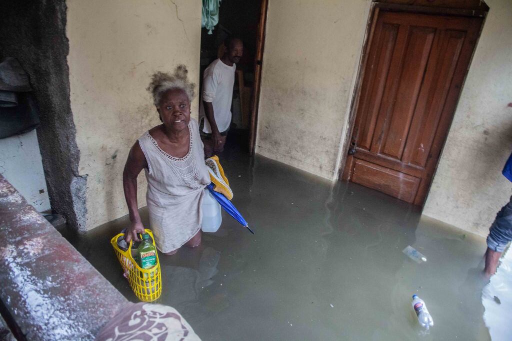 Las personas rescatan sus enseres por la inundación que dejó Grace en Haití