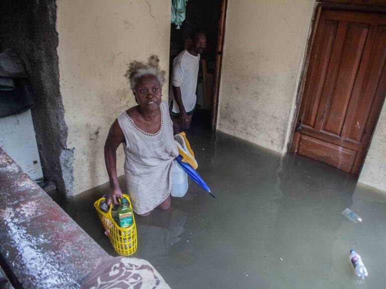 Las personas rescatan sus enseres por la inundación que dejó Grace en Haití