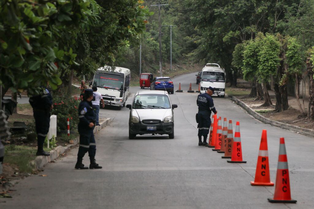 Oficiales de la Policía de El Salvador detienen vehículos para registrarlos en las rutas.