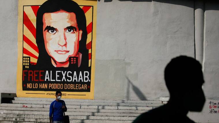 People walk past graffiti in favor of the release of Colombian businessman Alex Saab, amidst the Coronavirus pandemic, on the west side of the city in Caracas, Venezuela on September 8, 2021. (Photo by Javier Campos/NurPhoto via Getty Images)