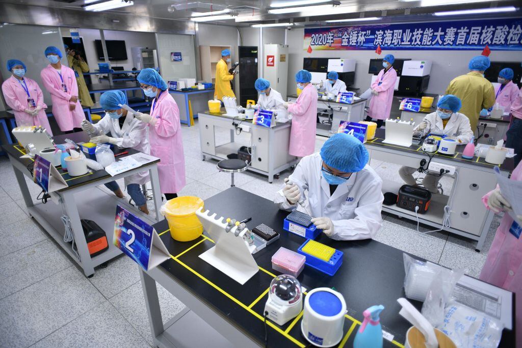 Técnicos médicos examinan muestras de test del coronavirus en China