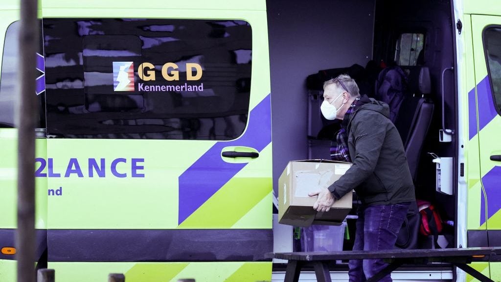 A man carries boxes from an ambulance parked in front of Ramada Hotel in Badhoevedorp near Schiphol airport where Dutch authorities have isolated 61 passengers who tested positive after arriving on two flights from South Africa on November 29, 2021. - Dutch health authorities said Saturday the new Omicron strain of Covid-19 was "probably" among some of the 61 passengers who tested positive after arriving on two flights from South Africa. (Photo by Kenzo TRIBOUILLARD / AFP) (Photo by KENZO TRIBOUILLARD/AFP via Getty Images)