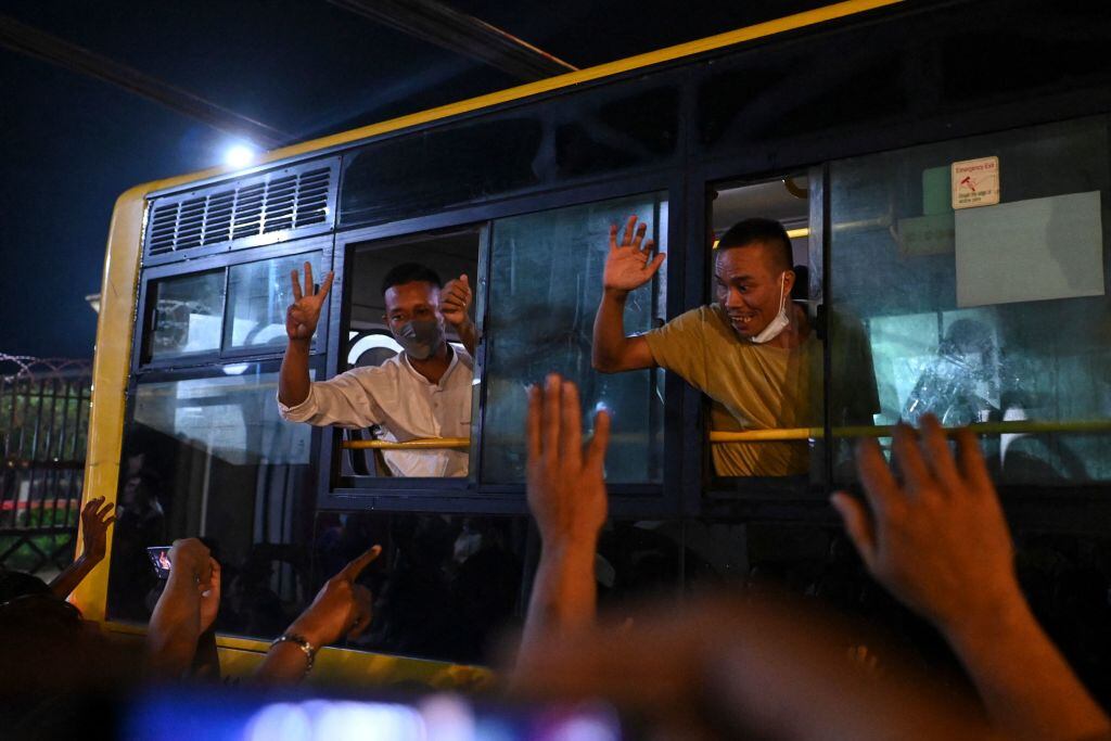 Prisioneros liberados saludan a las personas que los esperan fuera de la cárcel