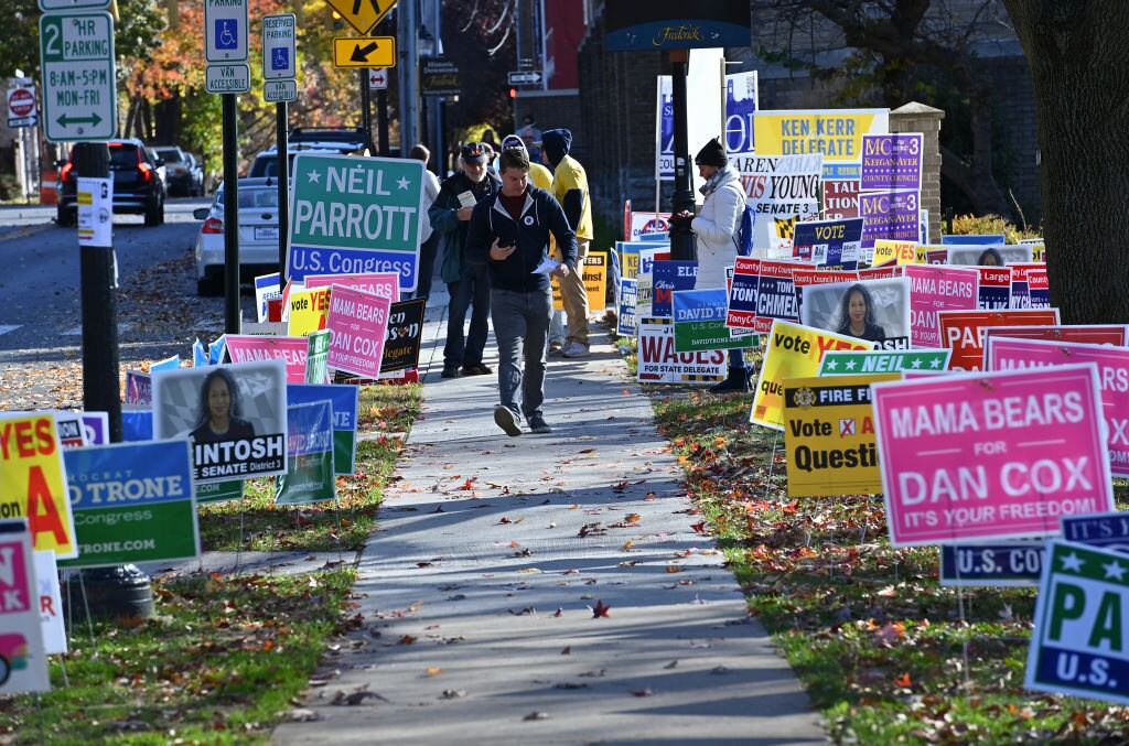 Personas por las calles de Maryland entre carteles de las elecciones