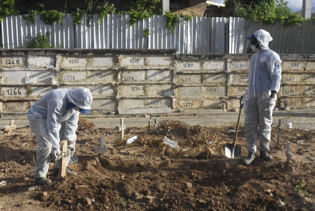 Trabajadores de un cementerio entierran a una víctima del Covid-19 en Río de Janeiro