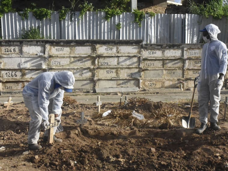 Trabajadores de un cementerio entierran a una víctima del Covid-19 en Río de Janeiro