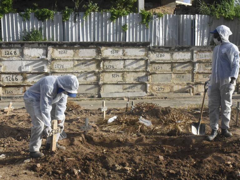 Trabajadores de un cementerio entierran a una víctima del Covid-19 en Río de Janeiro