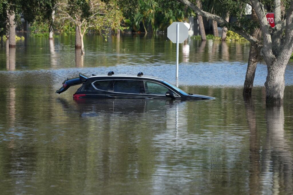 Un automóvil bajo el agua en medio de las inundaciones que deja el paso del huracán Milton por el estado de Florida en Estados Unidos