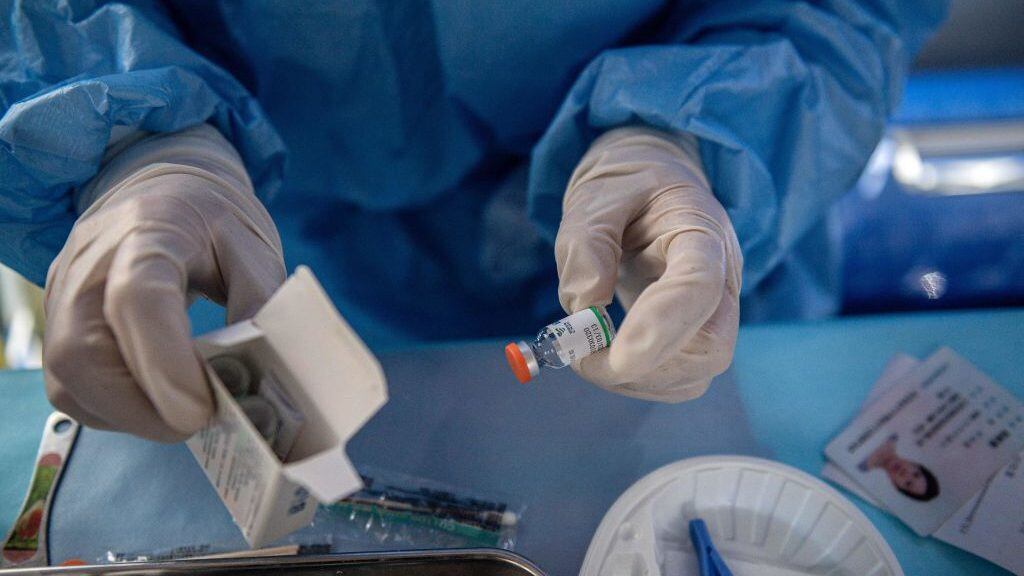 A nurse prepares a dose of the Sinopharm vaccine for a woman to get vaccinated against the Covid-19 coronavirus, on a mobile vaccination bus outside a residential area in Beijing on April 27, 2021. (Photo by NICOLAS ASFOURI / AFP) (Photo by NICOLAS ASFOURI/AFP via Getty Images)