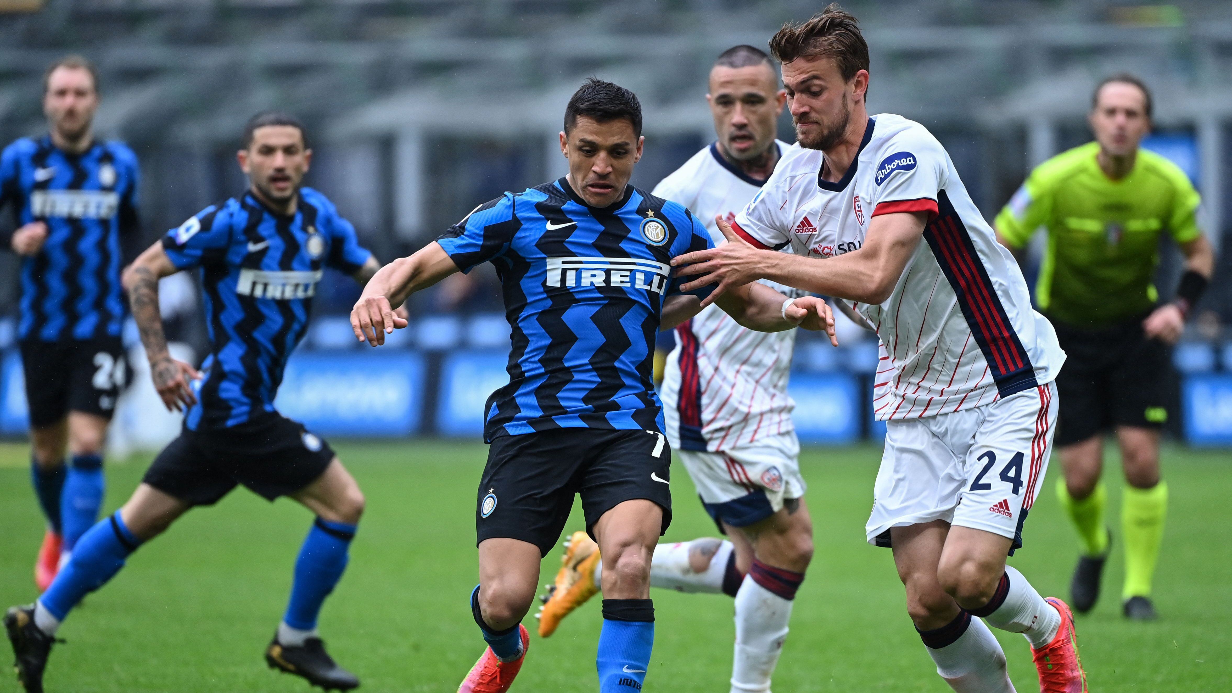 Inter Milan's Chilean forward Alexis Sanchez (c) challenges Cagliari's Italian defender Daniele Rugani during the Italian Serie A football match Inter Milan vs Cagliari on April 11, 2021 at the San Siro stadium in Milan. (Photo by Alberto PIZZOLI / AFP) (Photo by ALBERTO PIZZOLI/AFP via Getty Images)