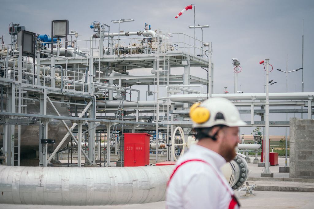 Trabajador camina ante planta procesadora de gas en Rumania