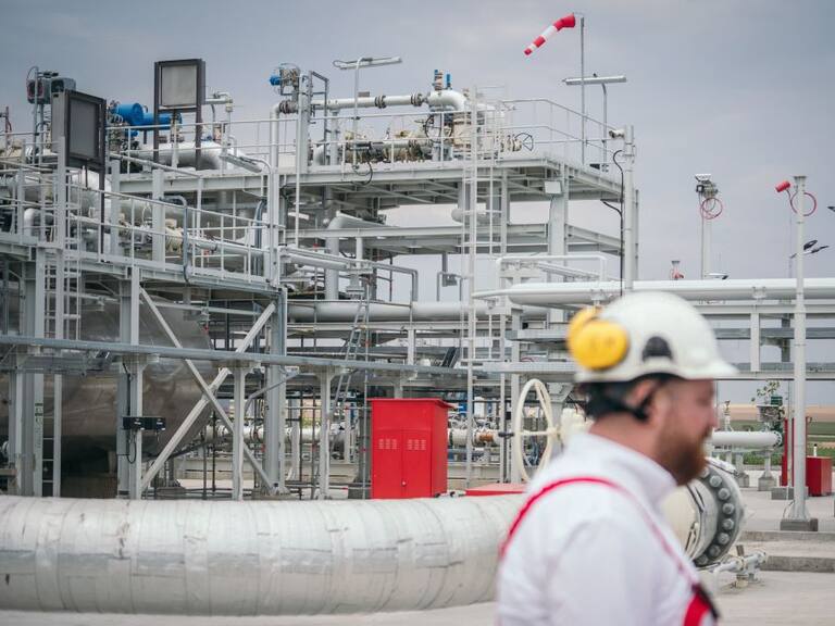 Trabajador camina ante planta procesadora de gas en Rumania