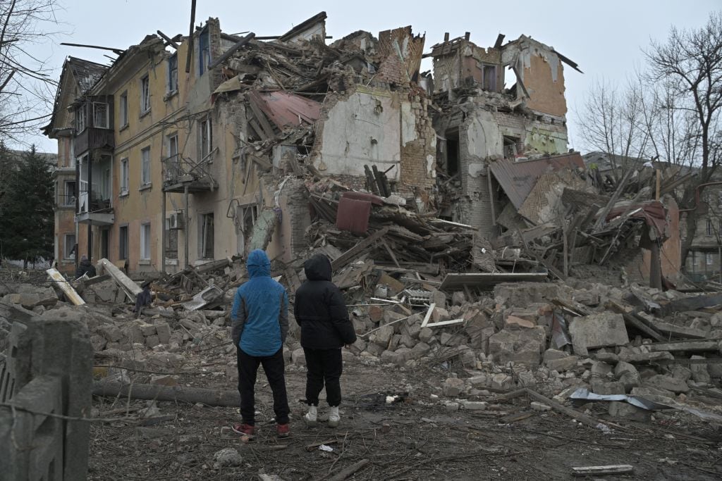 Personas observan la destrucción de un edificio que dejan los ataques aéreos de Rusia en la localidad de Selídove, en la región de Donetsk en Ucrania.