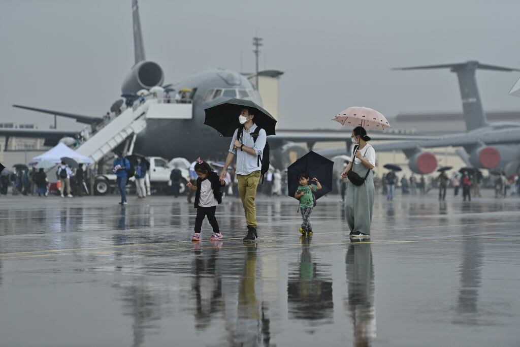 Turistas caminan en la pista de un aeropuerto local de la ciudad de Tokio
