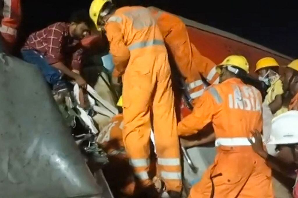 Los rescatistas sacan a personas del tren chocado en la India
