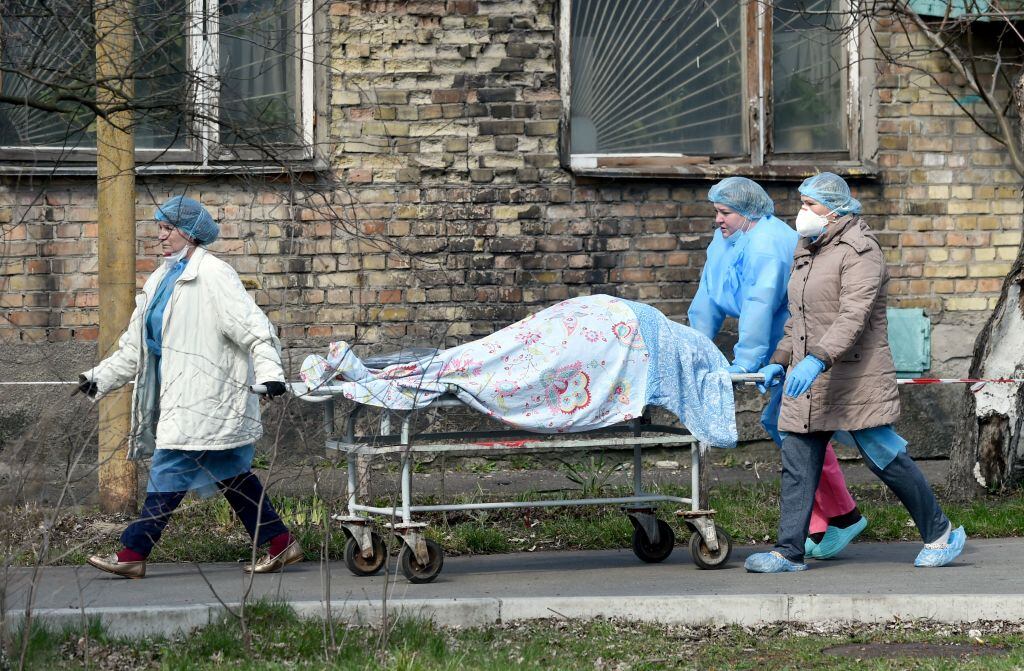 Trabajadores de la salud trasladan a una víctima del Covid-19 desde un hospital de Ucrania