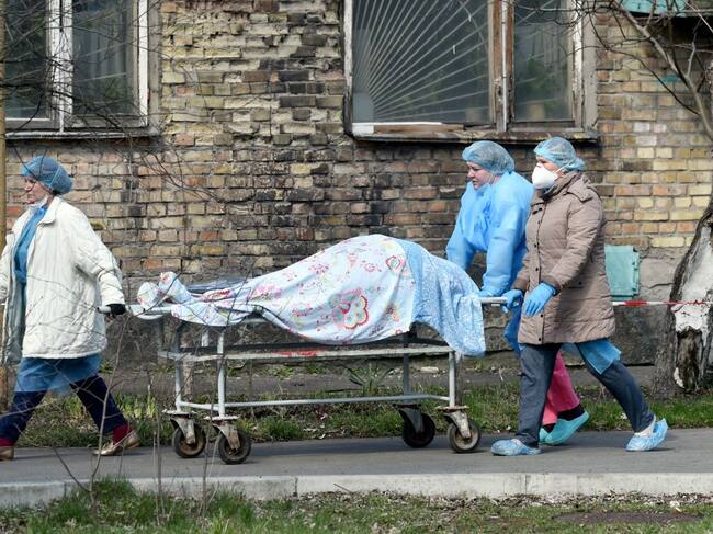 Trabajadores de la salud trasladan a una víctima del Covid-19 desde un hospital de Ucrania