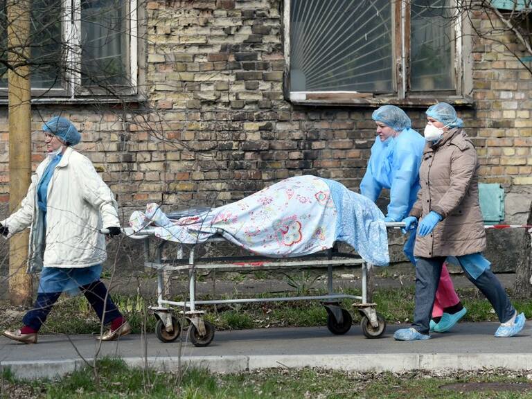 Trabajadores de la salud trasladan a una víctima del Covid-19 desde un hospital de Ucrania