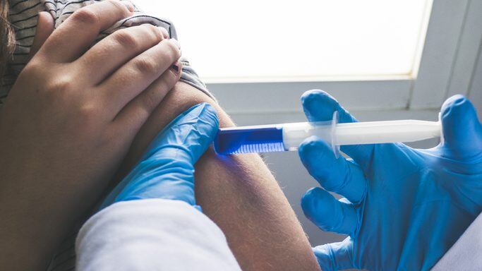 doctor giving a vaccination shot to a young woman
