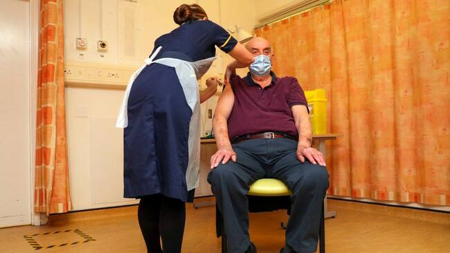 OXFORD, ENGLAND - JANUARY 04 82-year-old Brian Pinker receives the Oxford University/AstraZeneca COVID-19 vaccine from nurse Sam Foster at the Churchill Hospital in Oxford as the NHS increases its vaccination programme with 530,000 doses of the newly approved jab available for rollout across the UK on January 4, 2021 in Oxford, England. (Photo by Steve Parsons - WPA Pool/Getty Images)