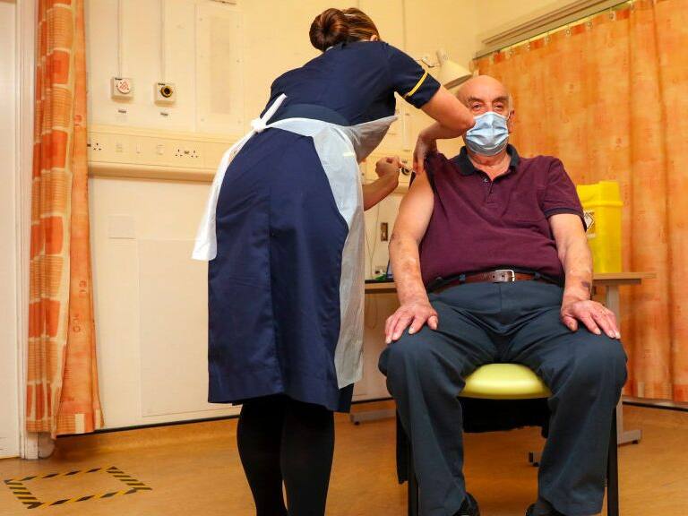 OXFORD, ENGLAND - JANUARY 04 82-year-old Brian Pinker receives the Oxford University/AstraZeneca COVID-19 vaccine from nurse Sam Foster at the Churchill Hospital in Oxford as the NHS increases its vaccination programme with 530,000 doses of the newly approved jab available for rollout across the UK on January 4, 2021 in Oxford, England. (Photo by Steve Parsons - WPA Pool/Getty Images)