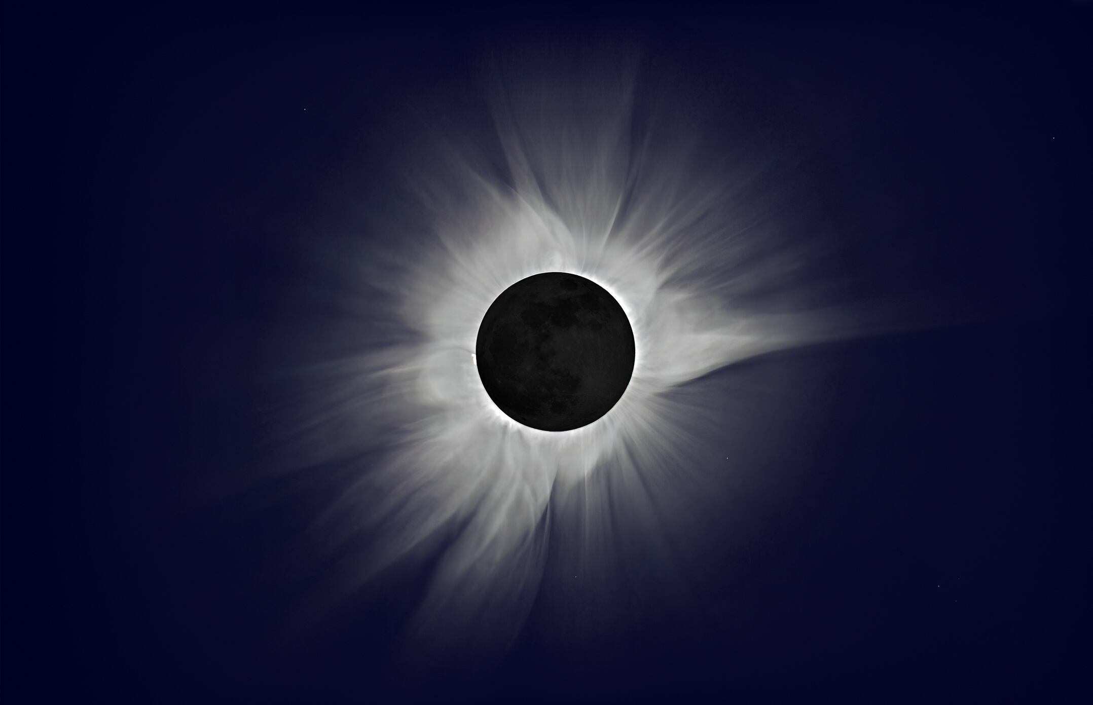 This is a photo of the March 9, 2016 total solar eclipse that I took on the path of totality from the small costal village of Pulau Dua on the East coast of Sulawesi Island, Indonesia.-
During the brief moment of "totality" (that lasted about 2 min), the Sun is completely hidden by the Moon, day becomes night (you can see stars), and you can then look directly at the total eclipse with the naked eyes, with no need for glasses or filters. And this is what you see!
-
The whitish hair-like structure around the Sun is called the "Corona", and can only be seen and photographed during the moment of totality, when the Sun is completely hidden by the Moon.
-
The Corona is formed by hot ionized gas particles (plasma) ejected by the Sun into space (eventually forming the "solar wind"). When they reach the Earth, those particles form aurora borealis ("northern lights"). The Corona continuously changes shape (very slowly) and it looks different for each total eclipse. The bright spot on the left is a prominence, i.e. giant splashes of sun's molten material.
-
I obtained this image using HDR processing, from just 3 exposures that I took with a regular DSLR camera and a 300mm telephoto, on a tripod. No filter was used since this photo was taken during the moment of "totality", when it is safe to look at the sun directly with the naked eyes.