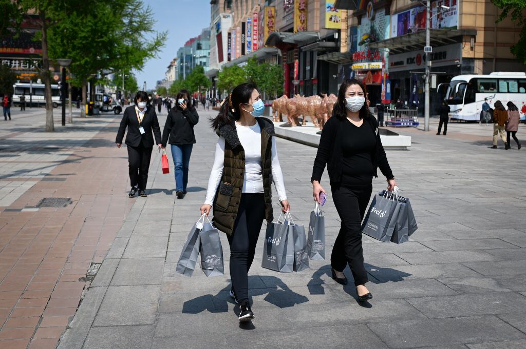 Dos mujeres con mascarillas realizan compras en Pekín