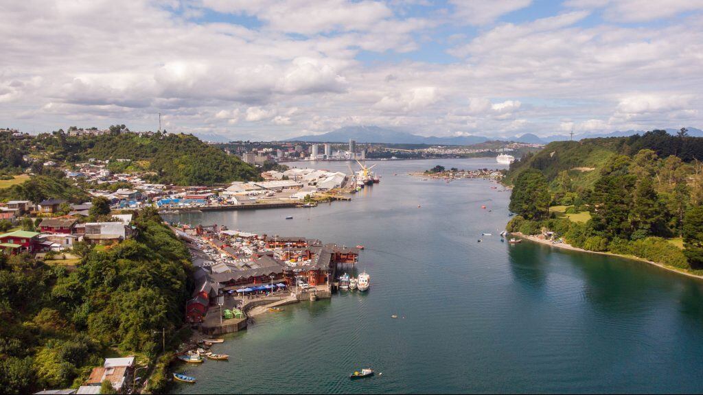 A drone aerial view of Puerto Montt city which appears Angelmo market and harbor at behind