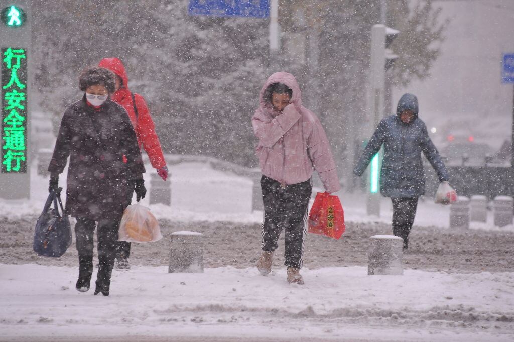Personas caminan en medio de una gran nevada al noreste de China