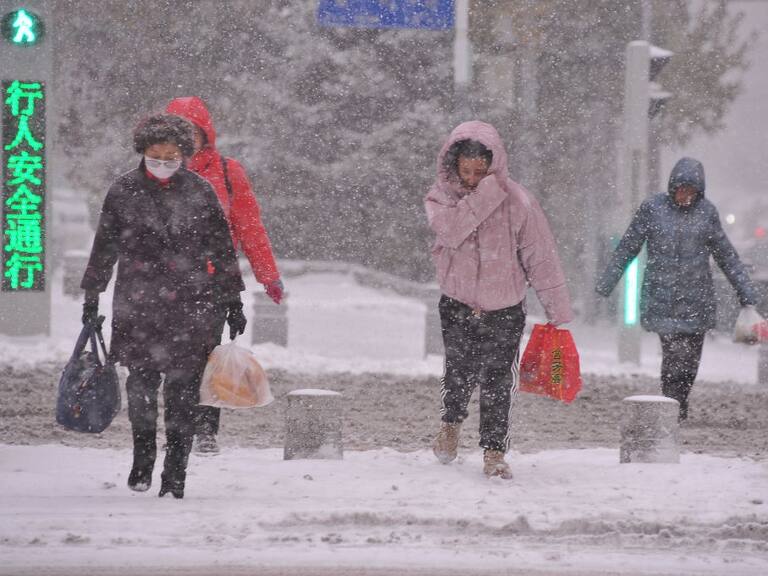 Personas caminan en medio de una gran nevada al noreste de China