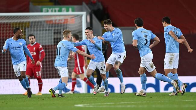 LIVERPOOL, ENGLAND - FEBRUARY 07: Phil Foden of Manchester City celebrates with team mates (L - R) Raheem Sterling, Oleksandr Zinchenko, John Stones and Ruben Dias after scoring their side's fourth goal during the Premier League match between Liverpool and Manchester City at Anfield on February 07, 2021 in Liverpool, England. Sporting stadiums around the UK remain under strict restrictions due to the Coronavirus Pandemic as Government social distancing laws prohibit fans inside venues resulting in games being played behind closed doors. (Photo by Laurence Griffiths/Getty Images)